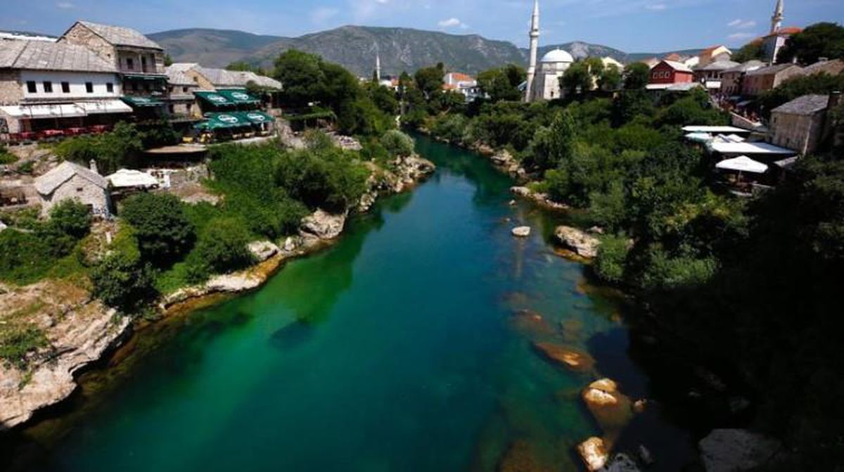 Bosna-Hersek bayrağı ve tarihi bir şehir manzarası