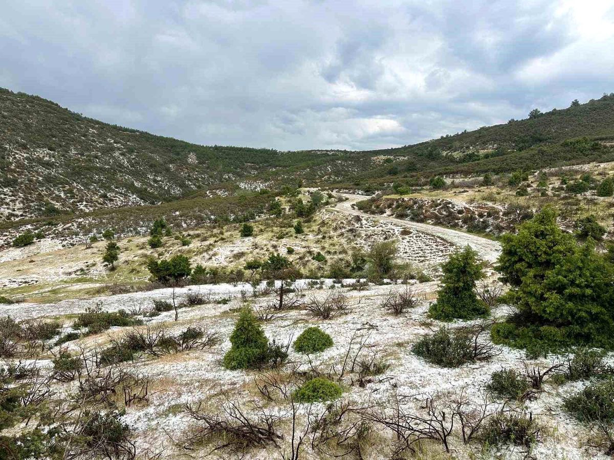 Uşak'ta yüksek kesimleri beyaza kaplayan dolu yağışından genel plan görüntü.