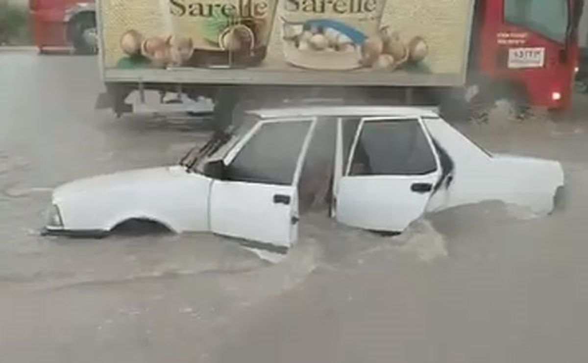 Denizli'de şiddetli yağış sonrası sular altında kalan bir cadde ve mahsur kalmış araçlar.
