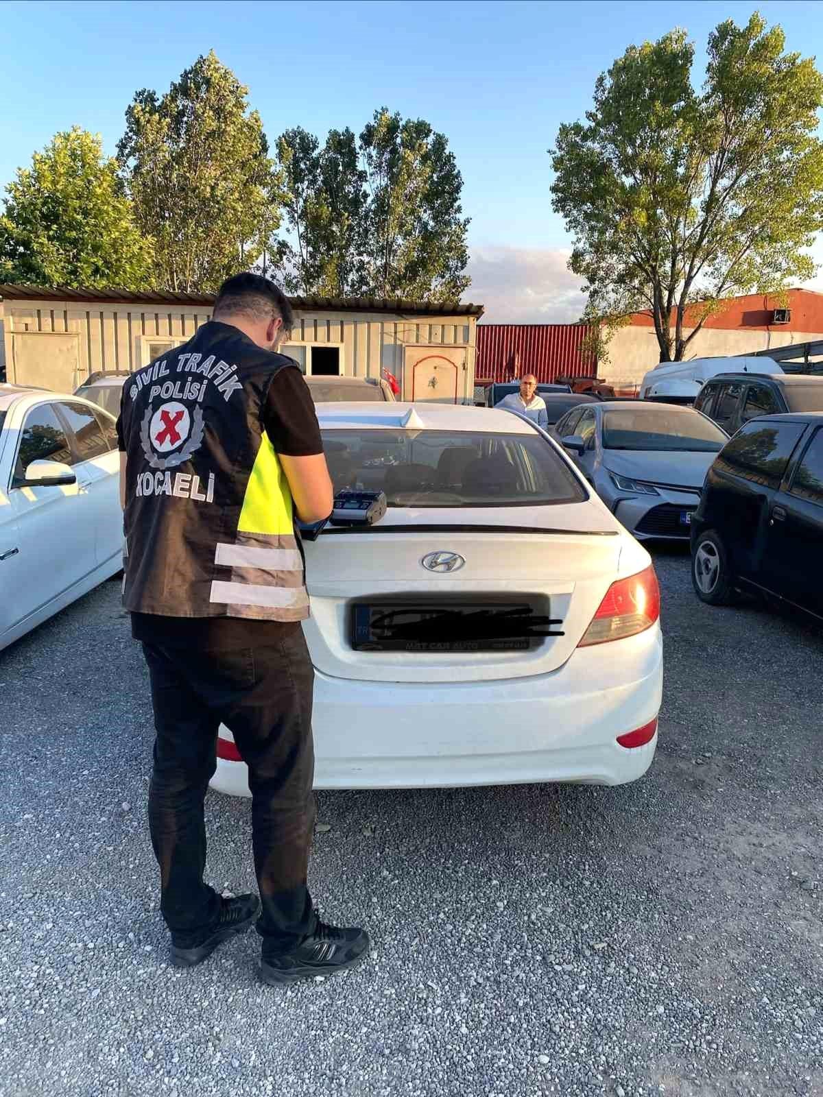 Kocaeli'de polis ekiplerinin durdurduğu bir otomobil ve sürücüsüne ceza kesildiği an.