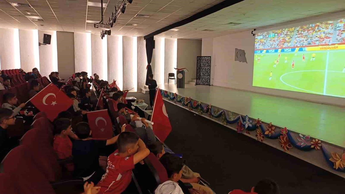 Van'da bir grup öğrenci, milli futbol maçını dev ekrandan izlerken heyecanlı görünüyor.