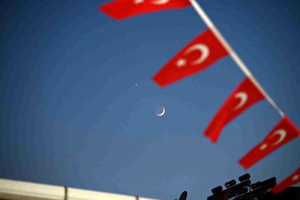 Demirci'de hilal ve Venüs gezegeninin Türk bayraklarıyla birlikte oluşturduğu kartpostallık manzara.