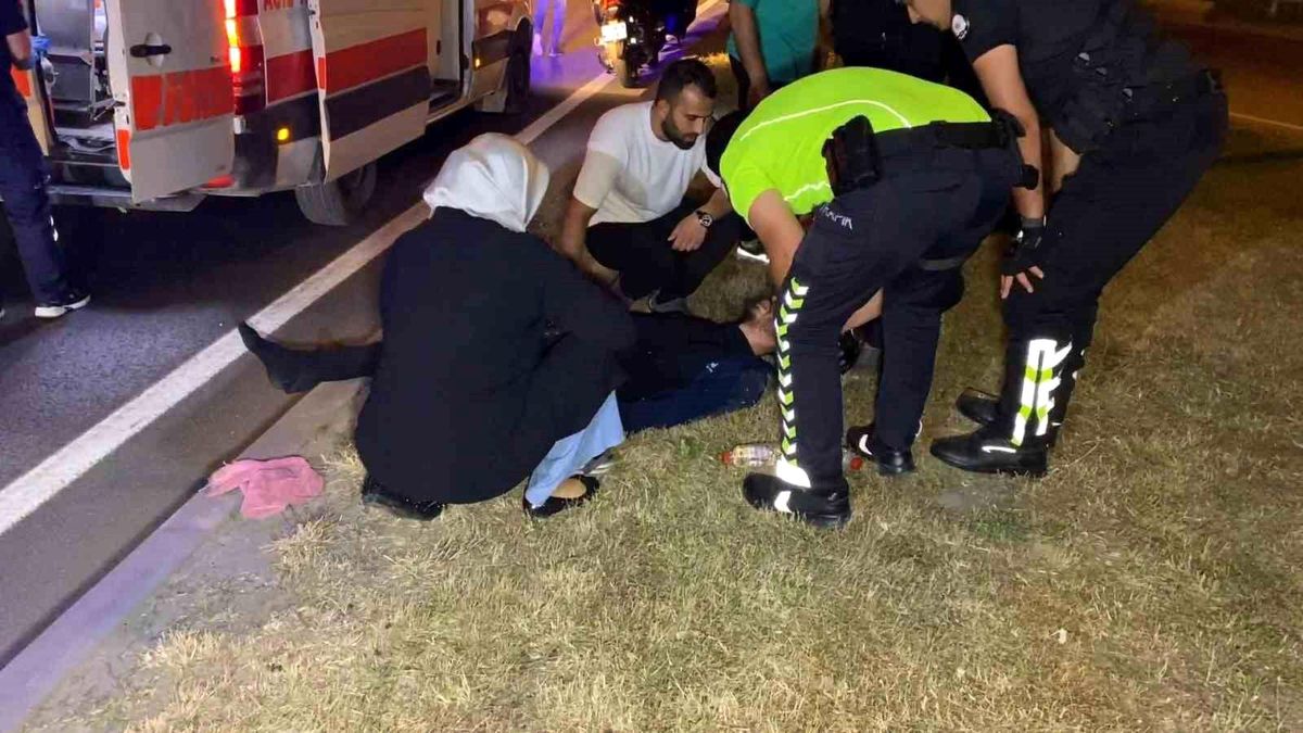Bursa'nın İnegöl ilçesinde motosiklet kazası sonrası yerde yatan yaralı sürücünün elini tutan annesi.