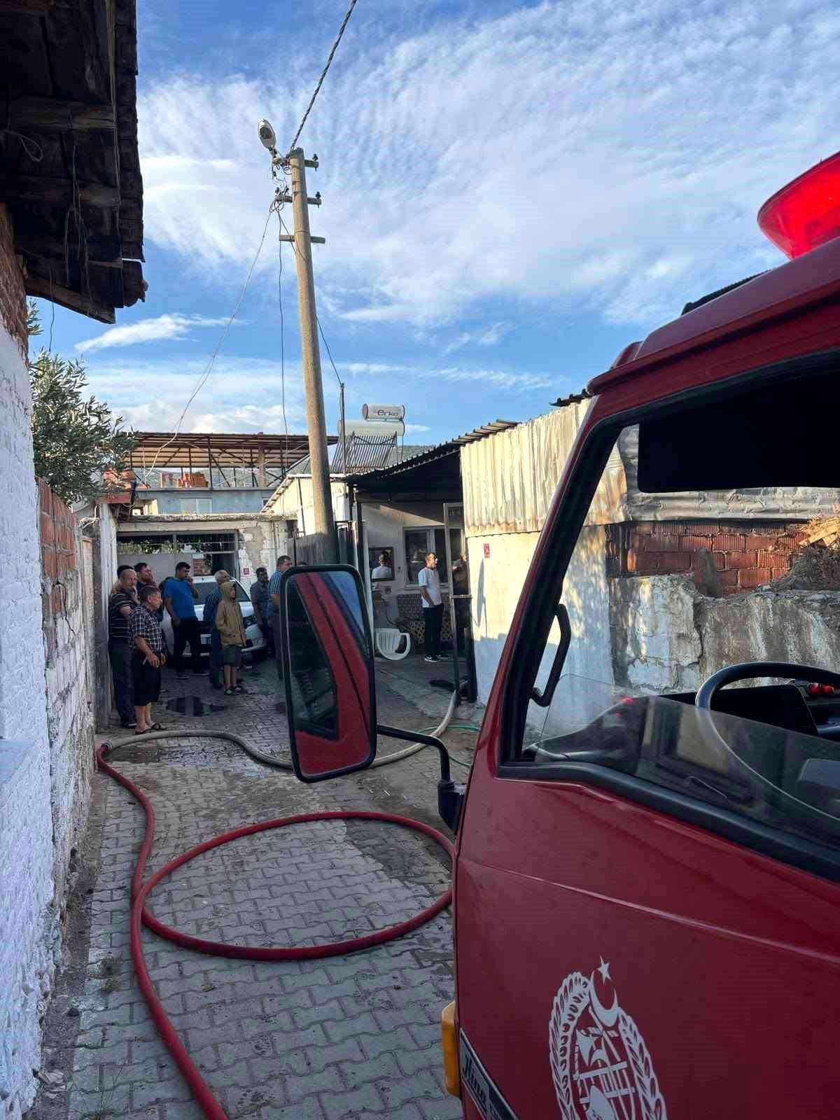 Balıkesir Burhaniye'de bir odunlukta çıkan yangın itfaiye ekiplerince söndürülüyor.