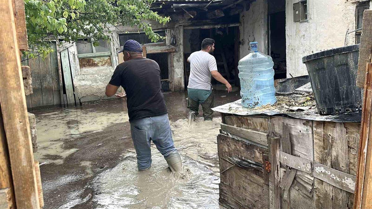 Burdur'da sağanak yağış sonrası su basan bir ev ve çamurlu bir cadde.