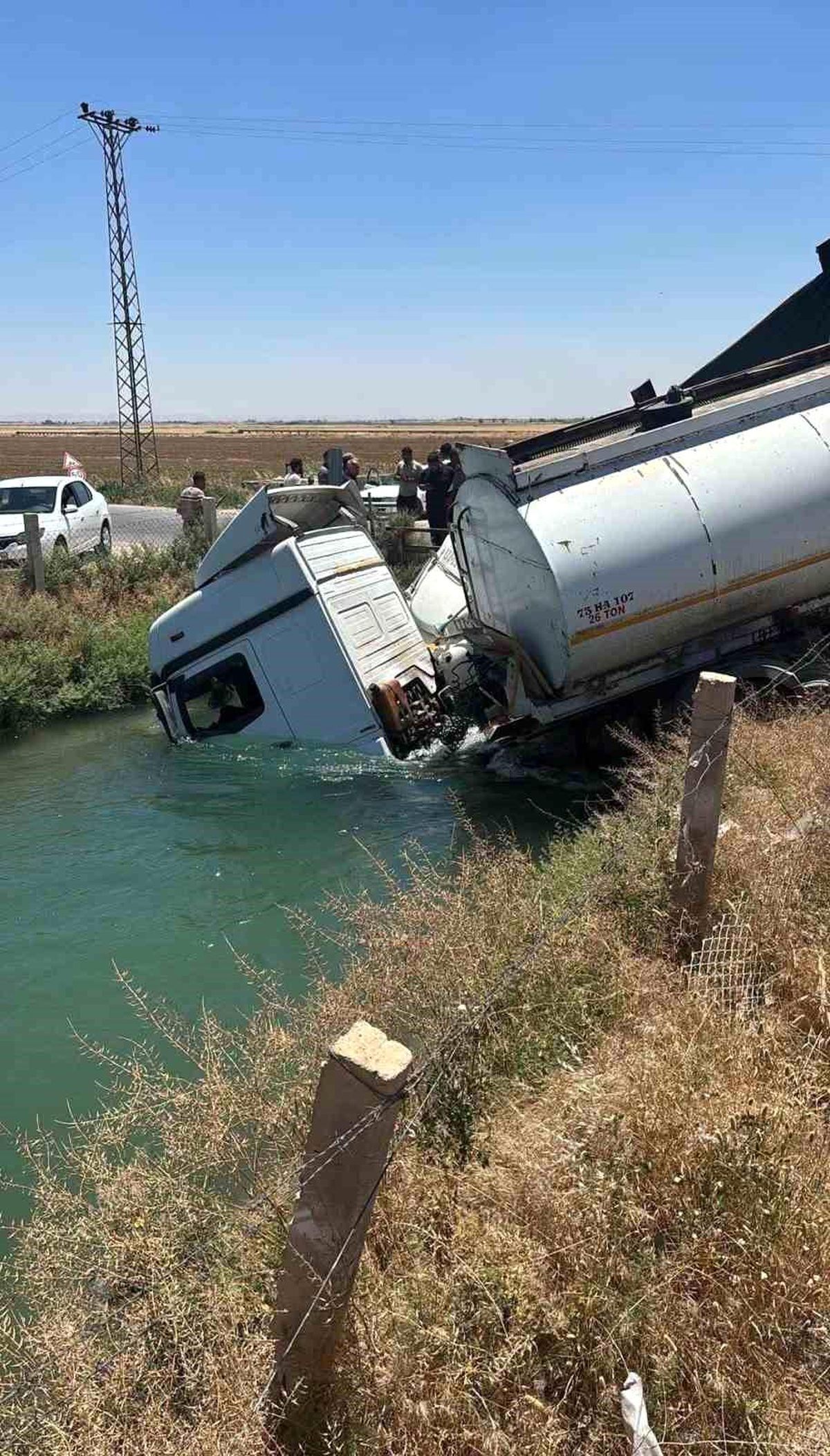 Şanlıurfa'da tanker ve kamyonun sulama kanalına devrildiği kaza yerinden görüntü.