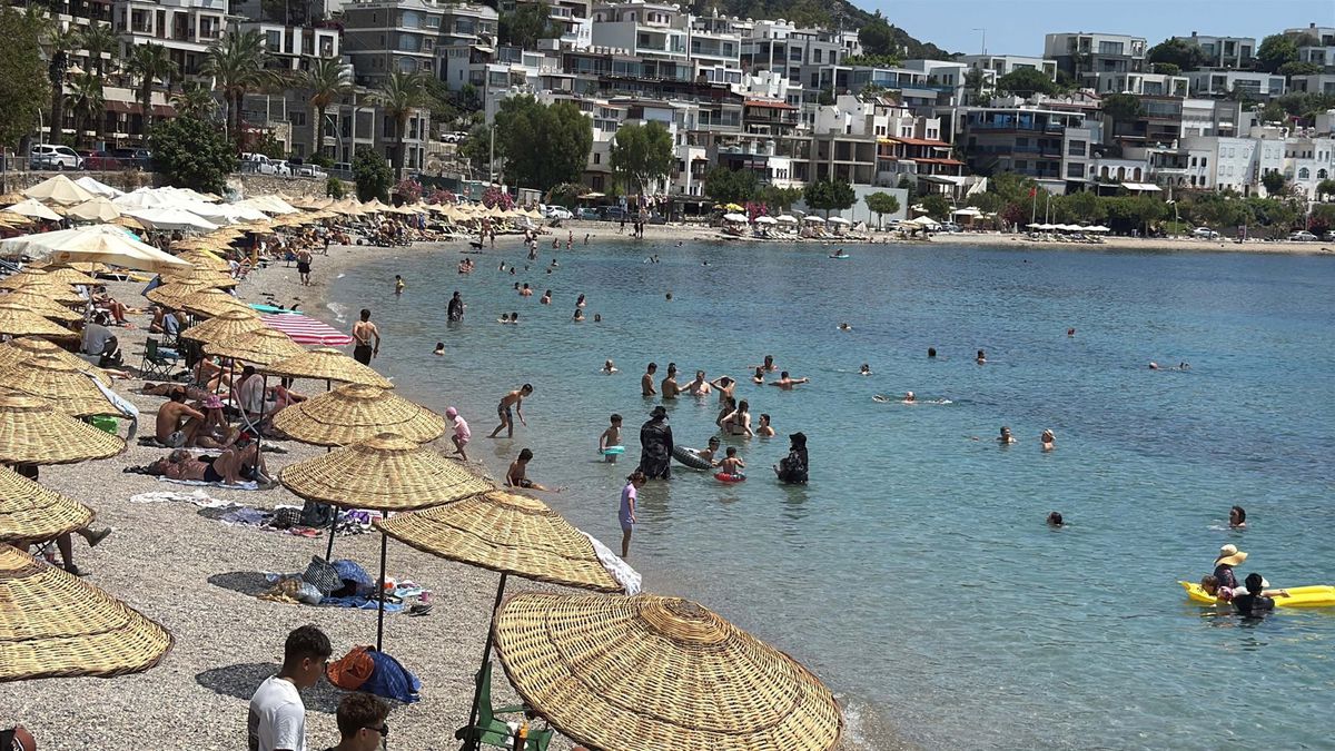Bodrum'da sahilde güneşlenen ve denize giren tatilciler