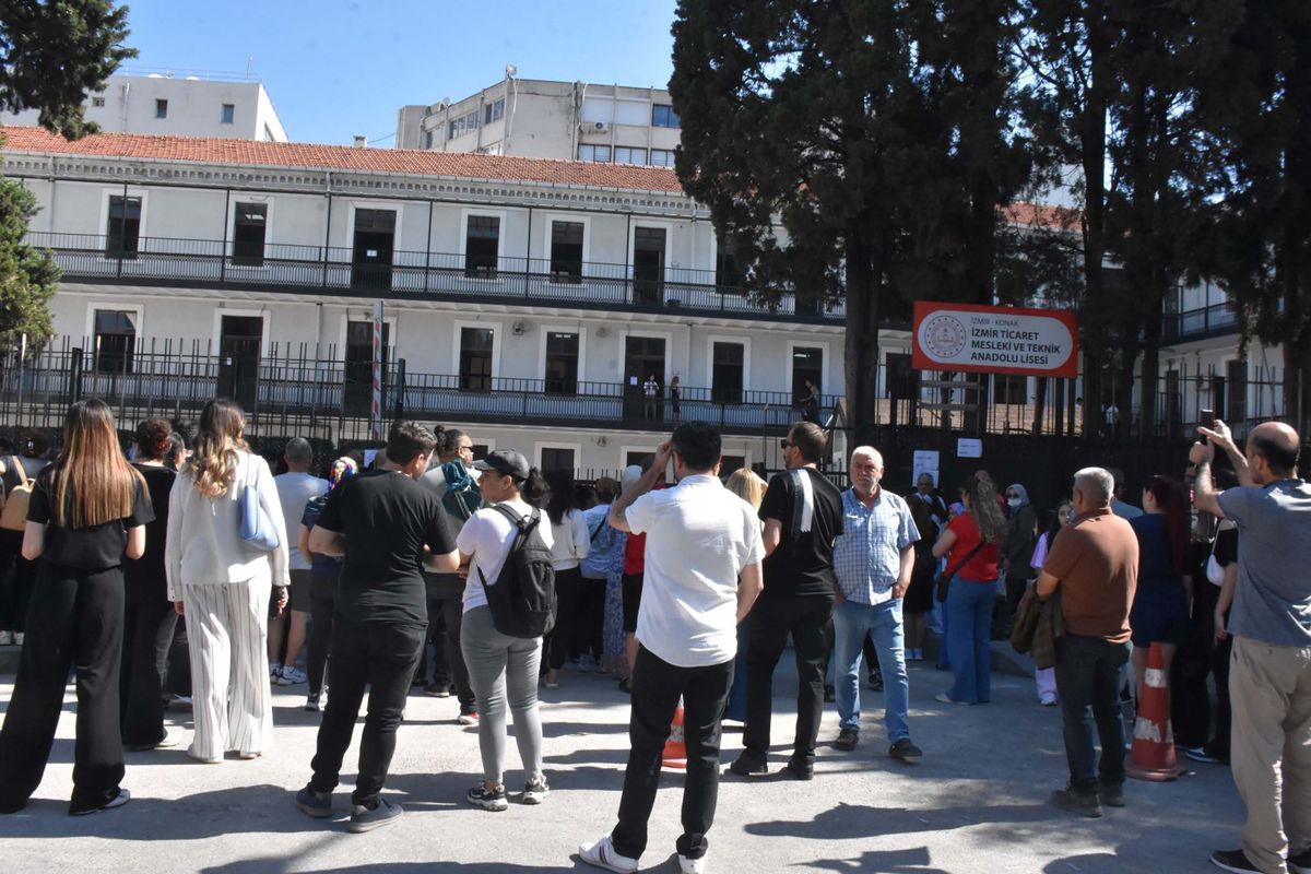 İzmir'de YKS AYT sınavı için adayların okullara girişi ve ailelerin bekleyişi.