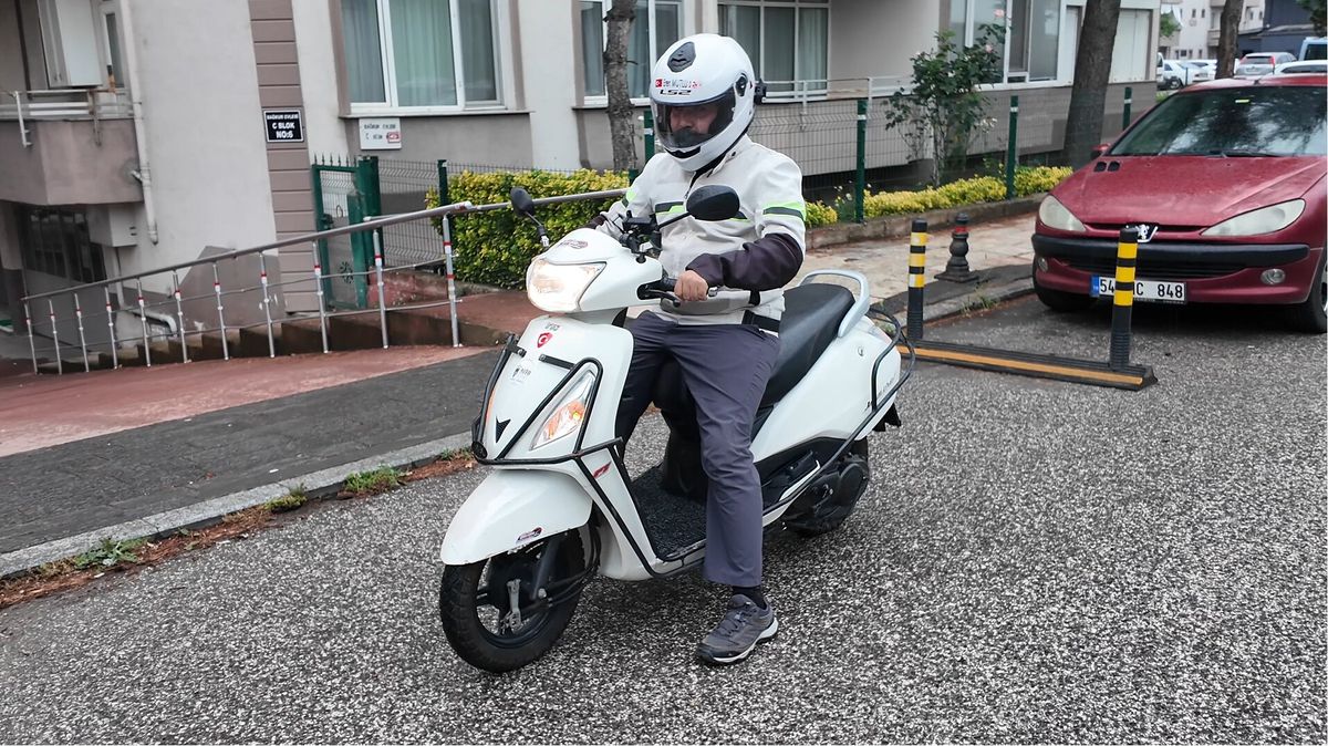 Eren Mutlu, 110 cc'lik motosikletiyle Türkiye haritası önünde duruyor.