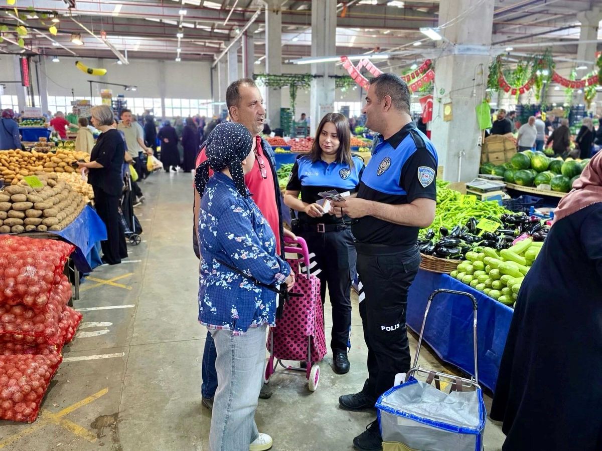 Bozüyük'te polis, kapalı pazar yerinde esnafa ve vatandaşlara sahte para ve dolandırıcılık konusunda bilgi veriyor.