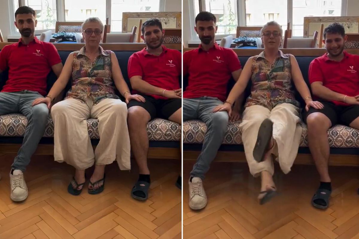 Nakliye çalışanlarına teşekkür eden bir kadının bacaklarına elini koyduğu anı gösteren video karesi.