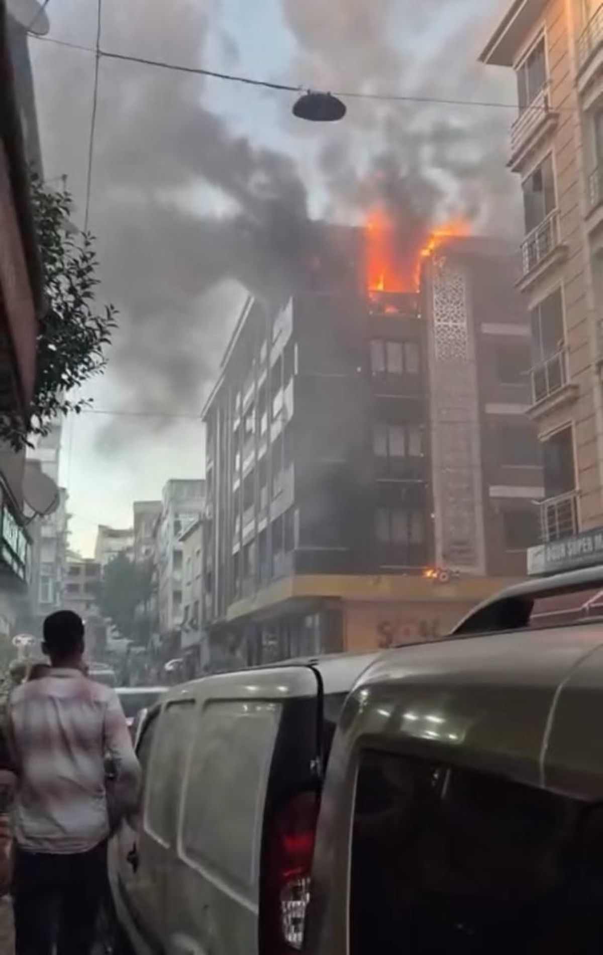 Esenler'de 4 katlı bir binanın çatısında yangın çıktı, itfaiye ekipleri alevlere müdahale ediyor.