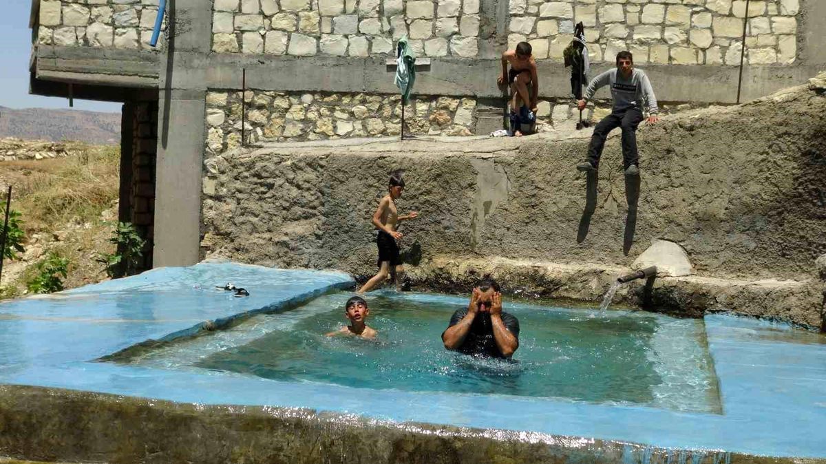 Gercüş ilçesinde sıcaktan bunalan çiftçiler buz gibi kaynak suyunda serinliyor