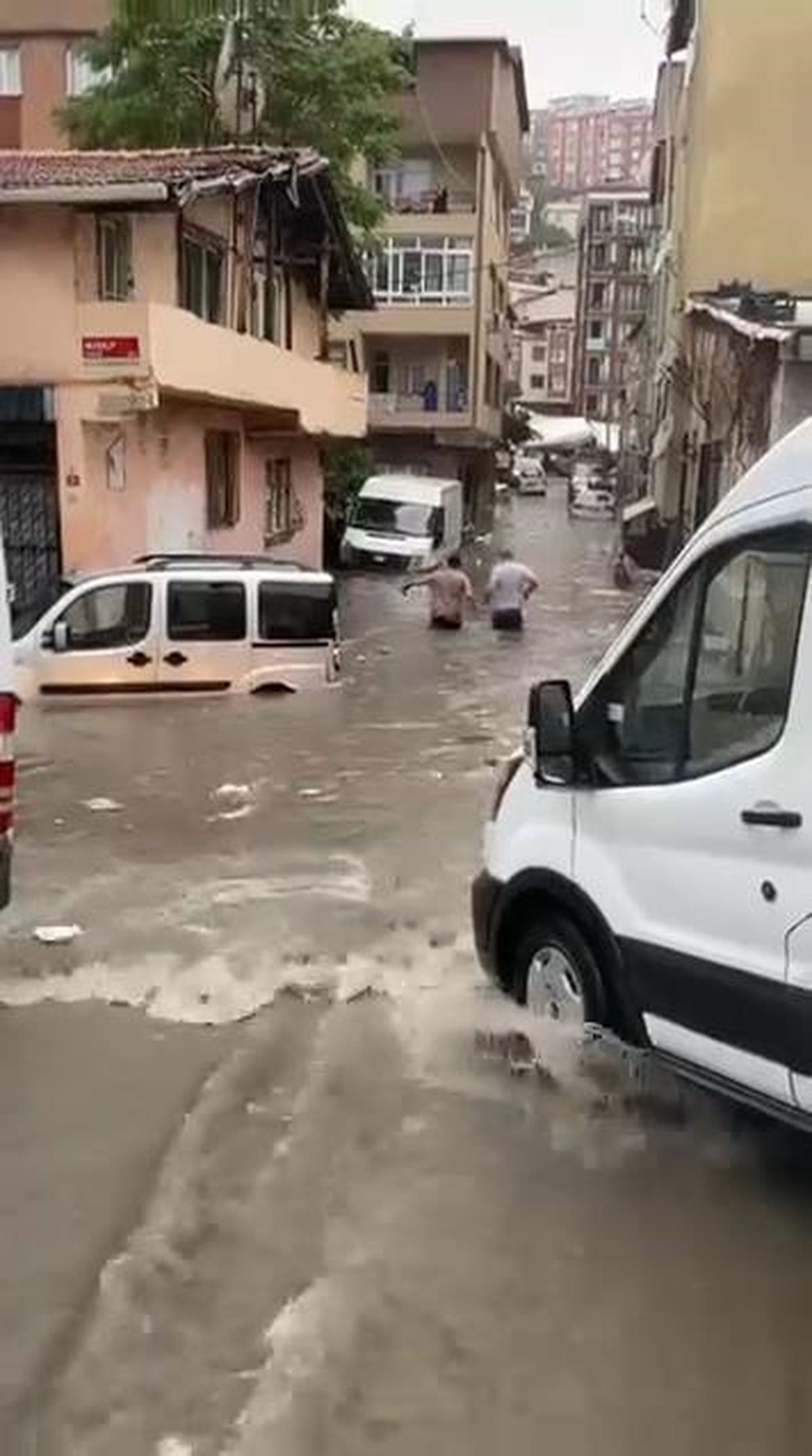 Kağıthane'de sel sularının bastığı bir cadde ve park halindeki araçlar.
