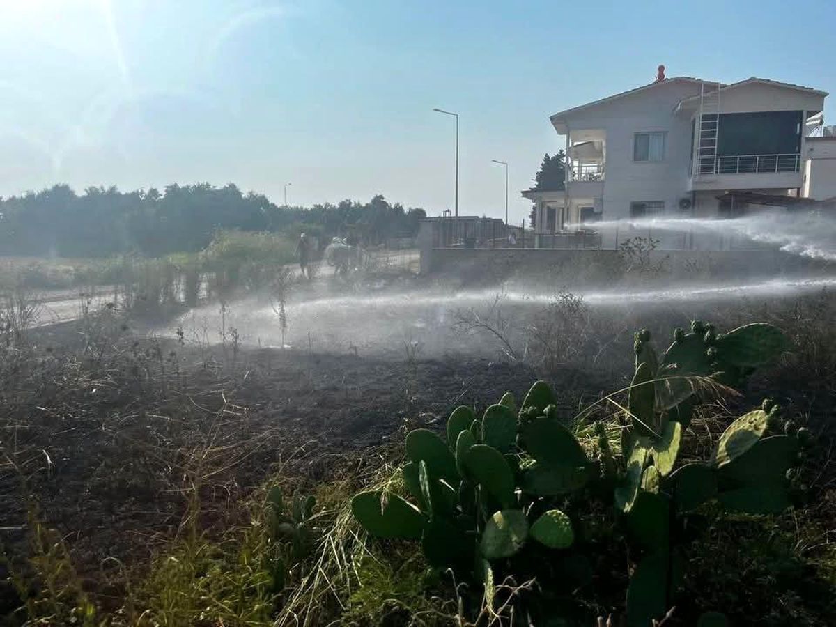 Hatay'ın Arsuz ilçesinde otluk bir alanda çıkan yangının söndürülme anı.