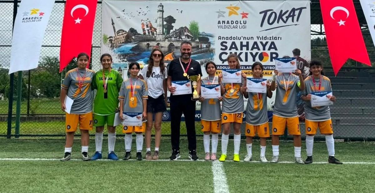 Erzincan kız futbol takımı oyuncuları şampiyonluk kupasıyla seviniyor.