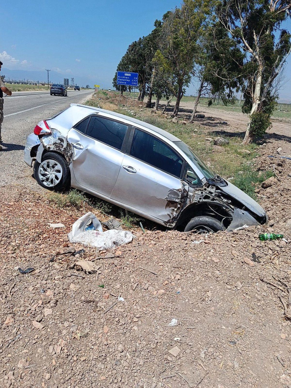 Hatay'ın Kırıkhan ilçesinde yol kenarına devrilmiş bir otomobil.