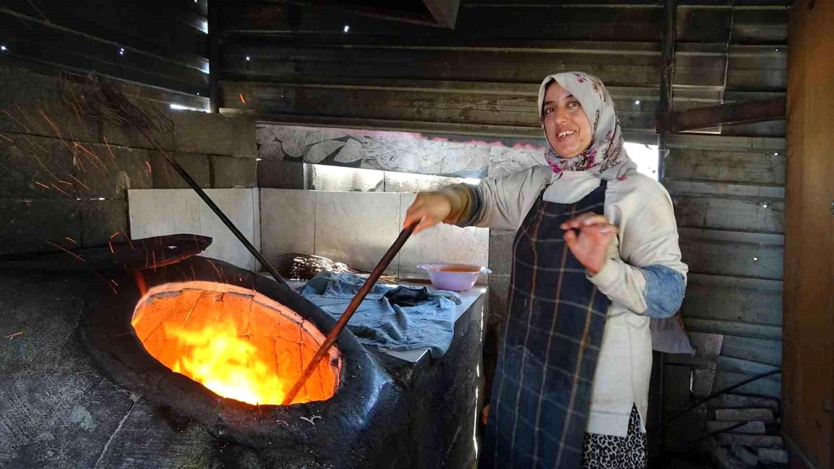 Hatay'da bir kadın, tandır ocağında ekmek pişiriyor.