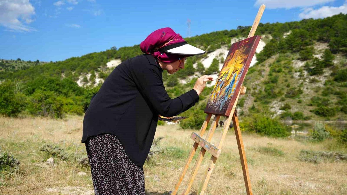 Ayfer Bozkurt'un sanat atölyesinde eserleriyle birlikte çekilmiş bir fotoğrafı.