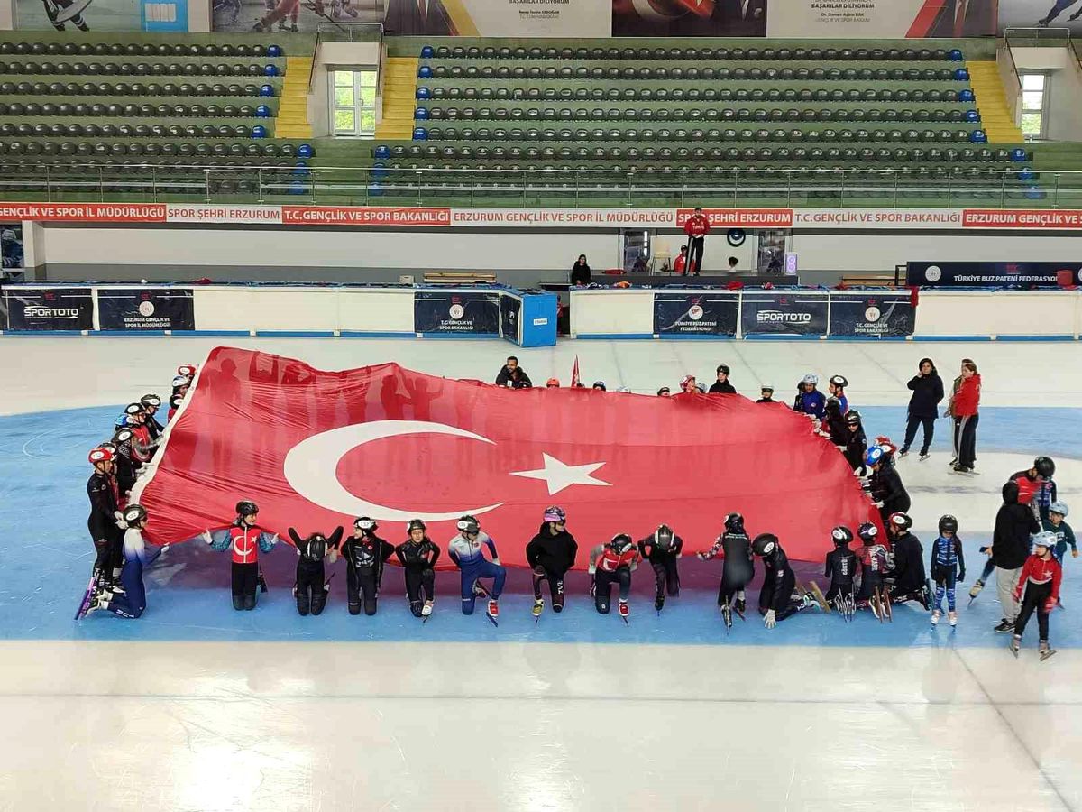 Milli buz pateni sporcuları 15 Temmuz anma etkinliğinde Türk bayrakları taşıyor.
