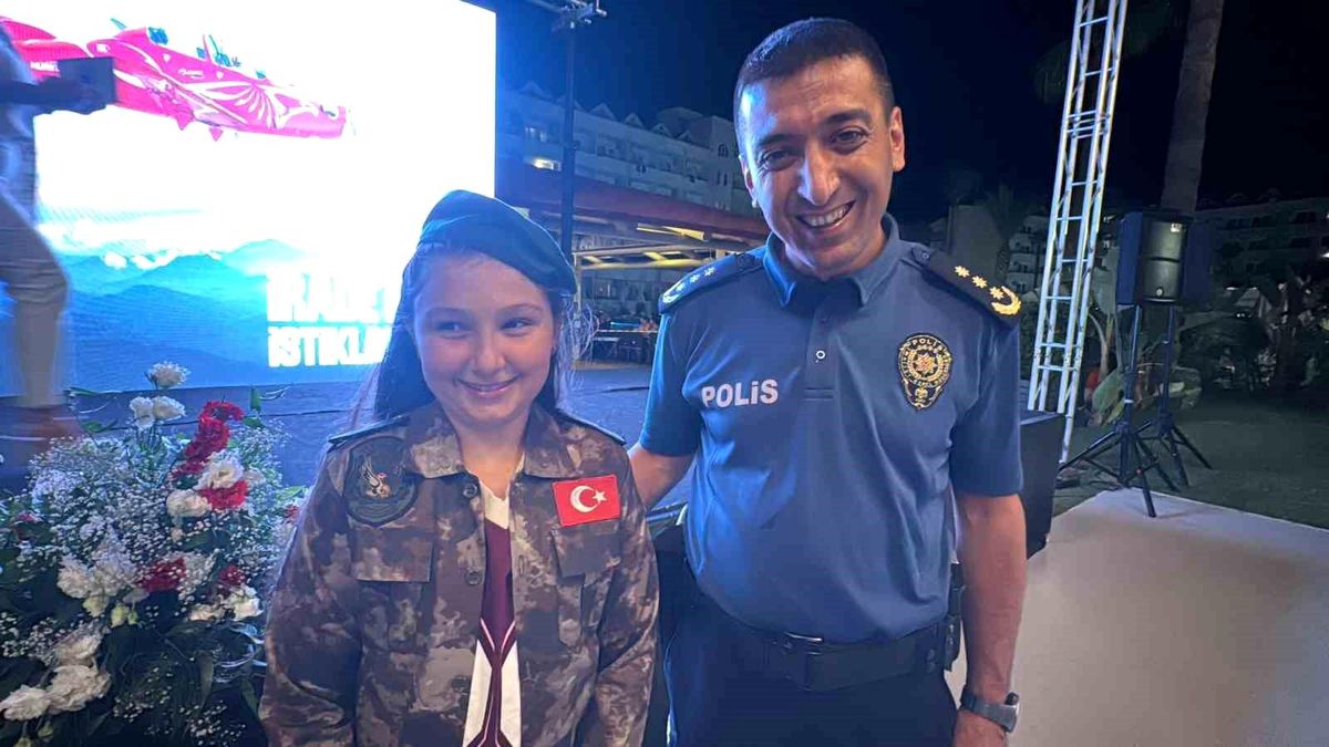 Marmaris'te 15 Temmuz anma programında şehit Gülşah Güler'in yeğenine polis üniforması hediye edilirken çekilmiş bir fotoğraf.