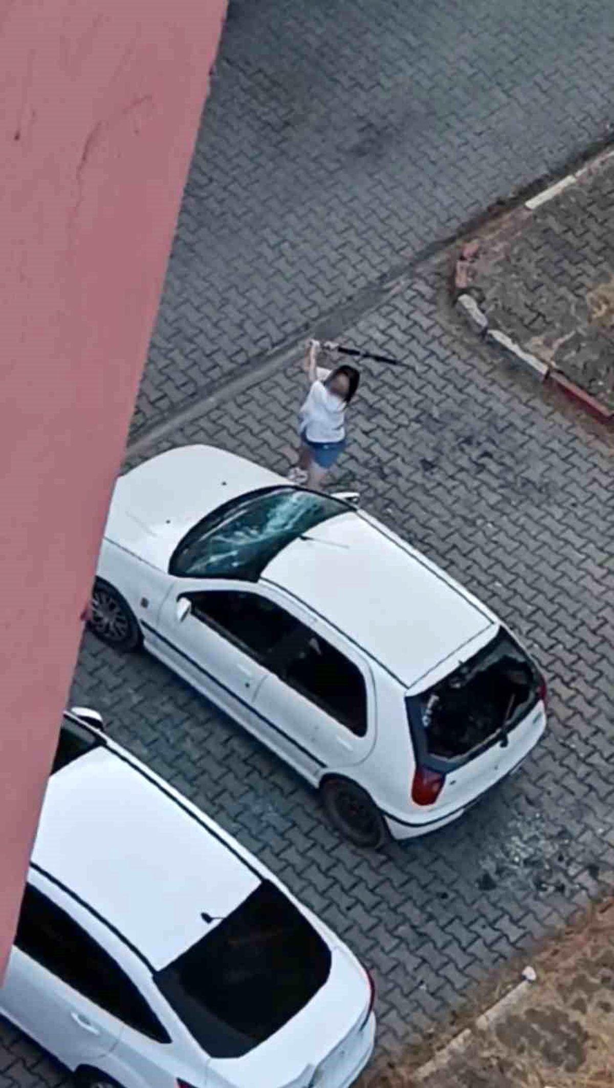 Park halindeki otomobilin camlarını kıran kadın kamerada