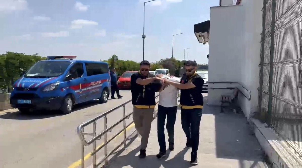 Adana'da kadın kılığına girerek iş yerine silahlı saldırı düzenleyen şüphelinin yakalanmasının ardından adliyeye sevk edilmesi.