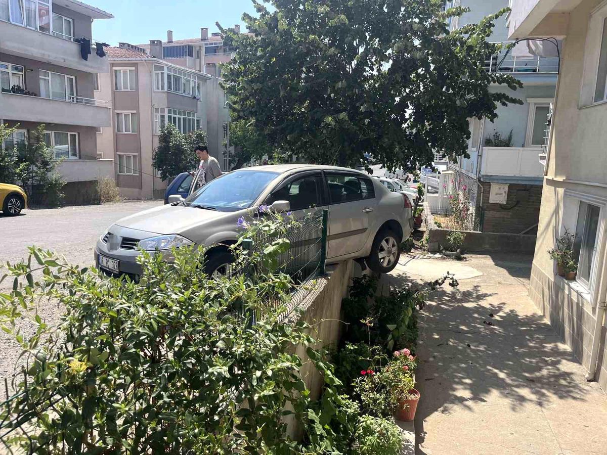 El frenini çekmeyi unuttu, otomobil bahçe duvarında asılı kaldı