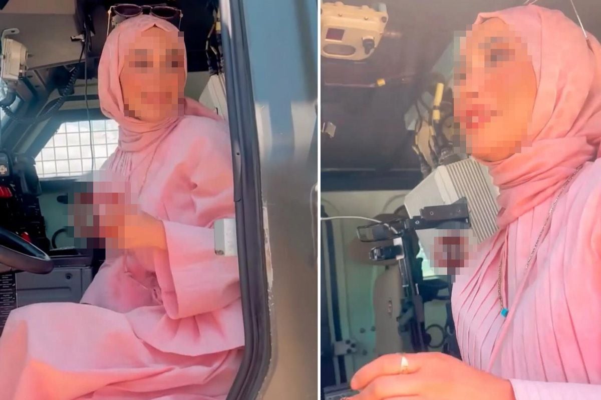 Özel Harekat polislerine ait zırhlı bir aracın üzerinde duran bir kadın.