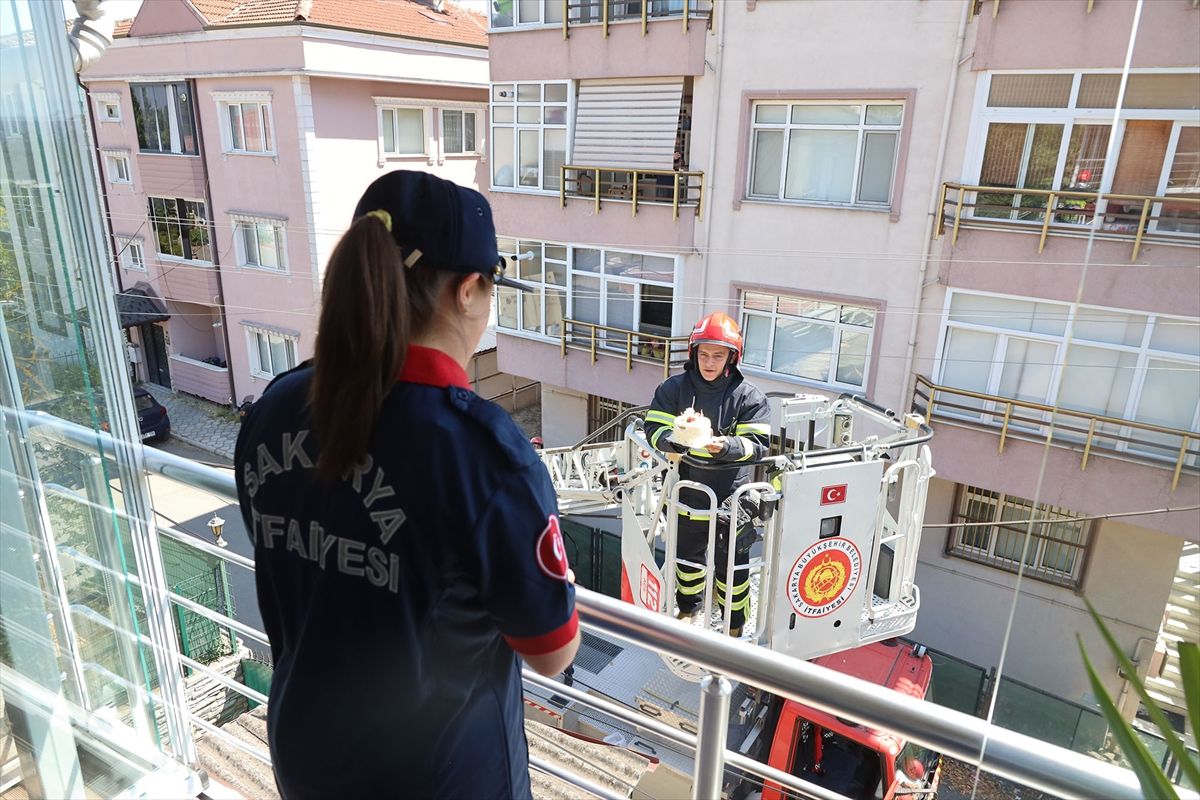 Down sendromlu Nihal Su Ekin, itfaiye üniforması giymiş ve elinde pasta tutuyor.