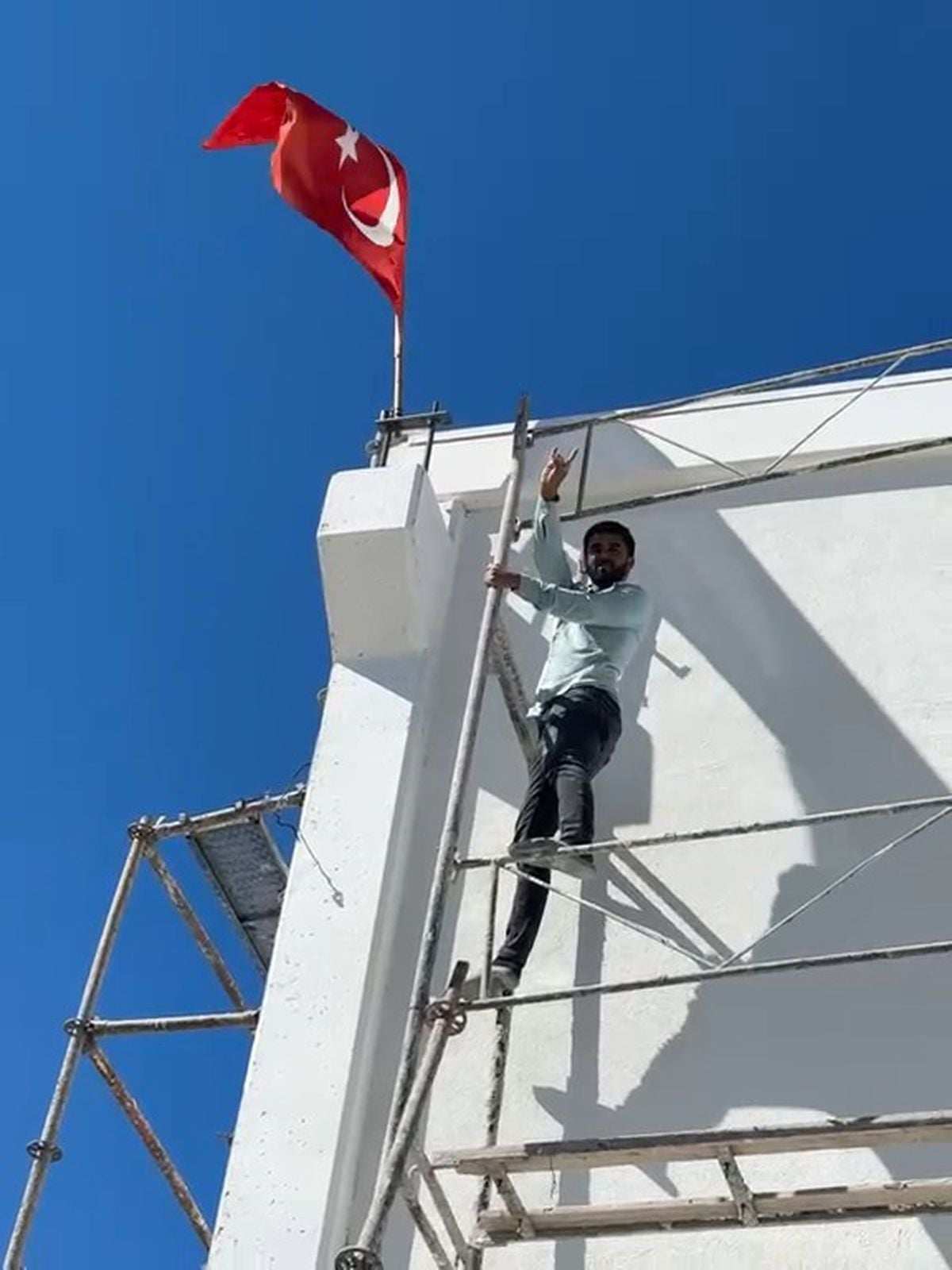 Rüzgarda ters dönen bayrağı düzeltmek için 10 metrelik iskeleye tırmandı
