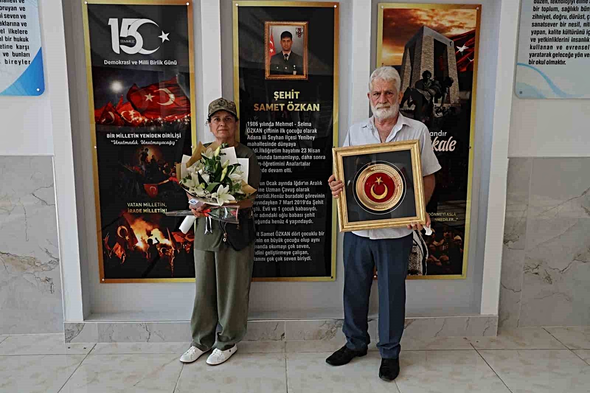 Şehit anne ve babası Türk bayrağıyla okulda