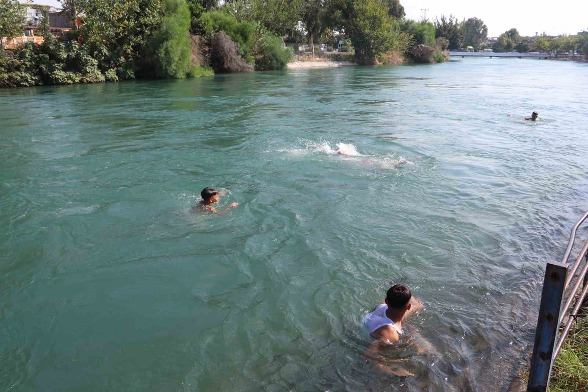 Adana'da hissedilen sıcaklık 40 dereceye yakınken çocuklar sulama kanalında serinliyor