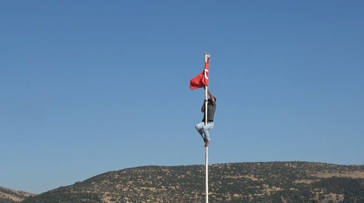 Kilis Polateli'de genç, direğe dolanan Türk bayrağını ayakkabılarını çıkarıp düzeltti