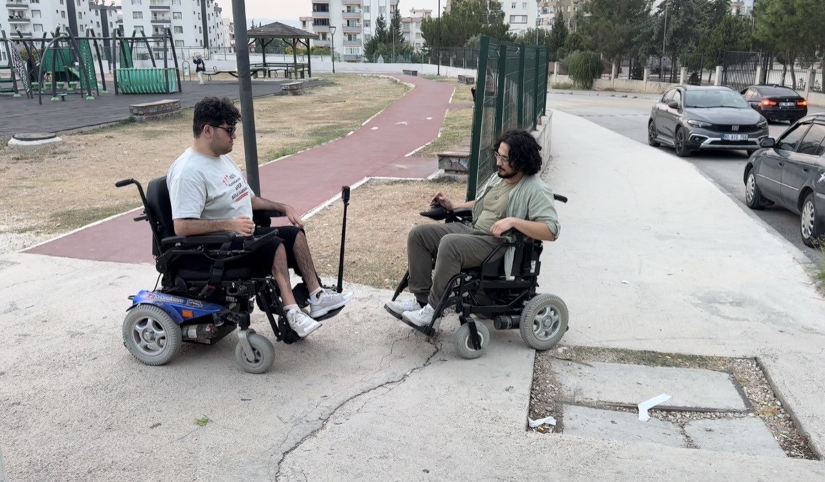 Osmaniye Kadirli'de Furkan Ulusoy, engelliler için arkadaşıyla akülü sandalyede gezdi