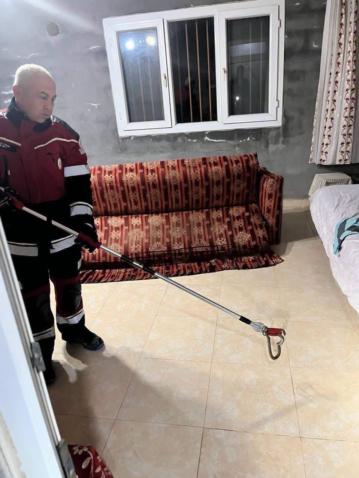 Hatay Samandağ'da yerleşim alanında görülen yılan itfaiyece yakalanıp doğaya salındı