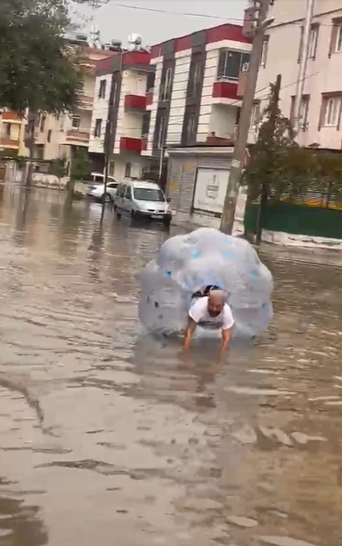 Mersin Tarsus'ta sağanakta göle dönen caddede balonla ilerleyen kişi görüntülendi