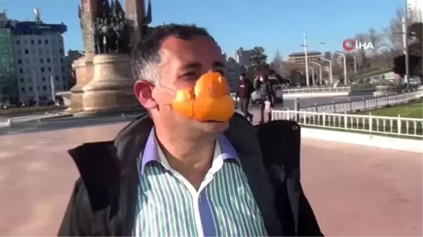 Portakaldan yaptığı maske ile türkü söyleyerek Taksim'de yürüdü