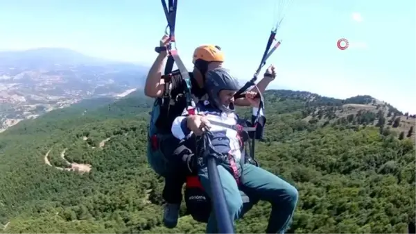 Yamaç paraşütü ile atlayan sanatçı bin metre yükseklikte şarkı söyledi