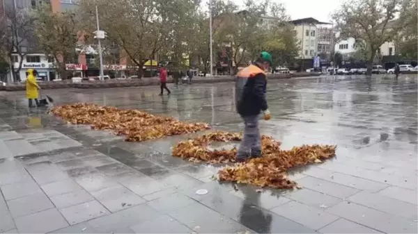 Temizlik işçisi ağaçlardan düşen yapraklarla 