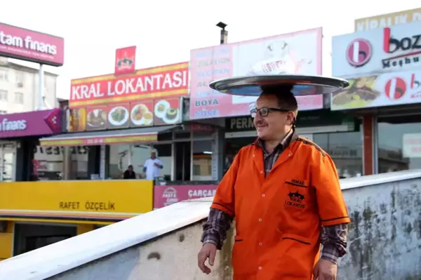 Sipariş verilen yemekleri kafasında taşıdığı tepsi ile götürüyor